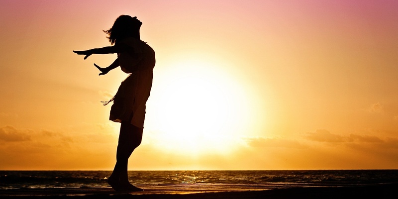 Woman stretching at sunset signifying divorce and a new start