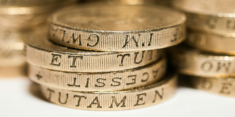 Pound coins pictured from the side indicating whether an employer can withhold pay when an employee is suspended on criminal charges.